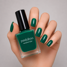 Load image into Gallery viewer, Hand with bright green nail polish holding a bottle of peelaboo weekender nail polish.