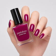 Load image into Gallery viewer, Hand with purplish red nail polish holding a bottle of peelaboo weekender nail polish.