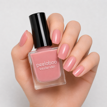 Load image into Gallery viewer, Hand holding a bottle of peelaboo weekender nail polish with matching nails on a light background
