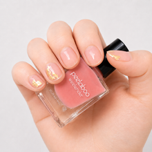 Load image into Gallery viewer, Peelaboo Sheer Blush Gold Kit — hand with gold foil nail art next to Semi-bloom pink peel-off nail polish bottle