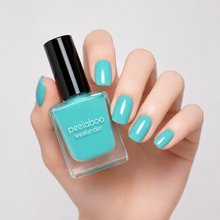 Load image into Gallery viewer, Hand with pastel teal nail polish holding a bottle of peelaboo nail polish against a light gray background