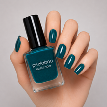 Load image into Gallery viewer, Hand with deep teal nail polish holding a bottle of peelaboo weekender nail polish.
